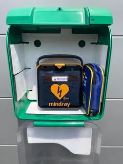Armoire Aivia ouverte contenant un défibrillateur Mindray dans sa housse et une trousse d'accessoires